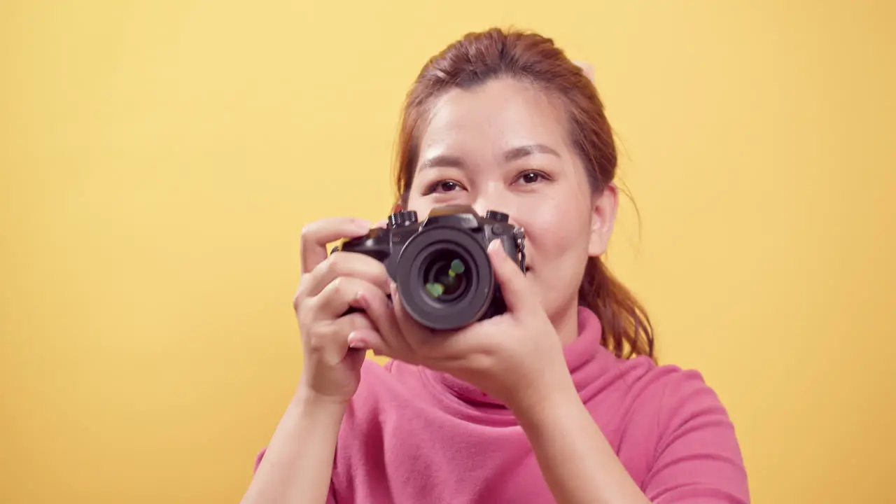 Asian gorgeous young woman in a studio shot over an isolated yellow background using a digital camera with copy space for advertising-1