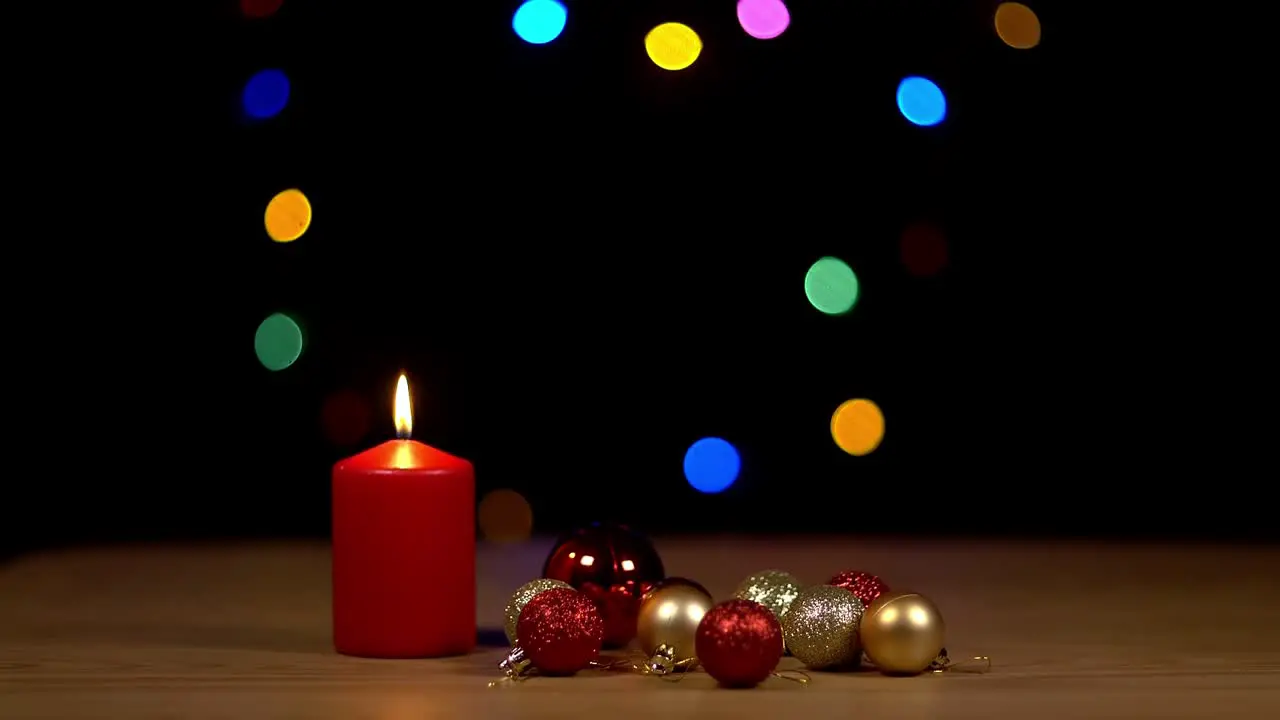 Candle next to christmas ornament with bokeh background