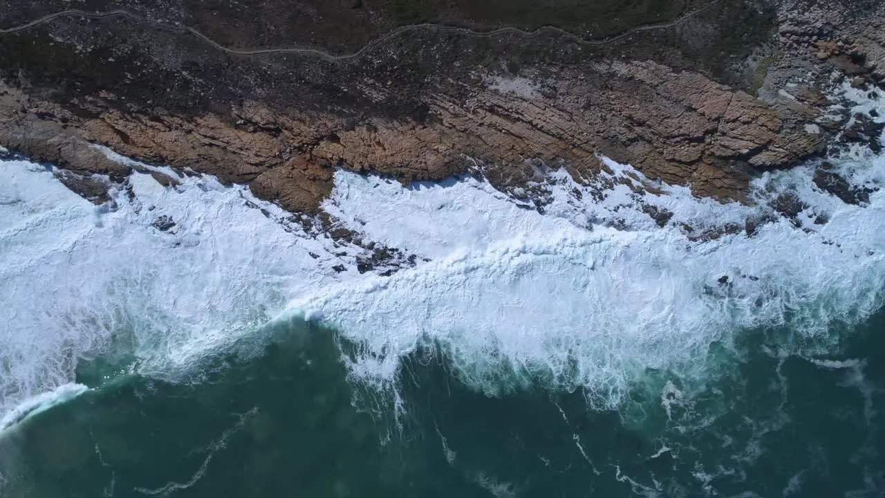 Aerial of waves breaking on rugged South African coastline Kleinmond Overstrand South Africa