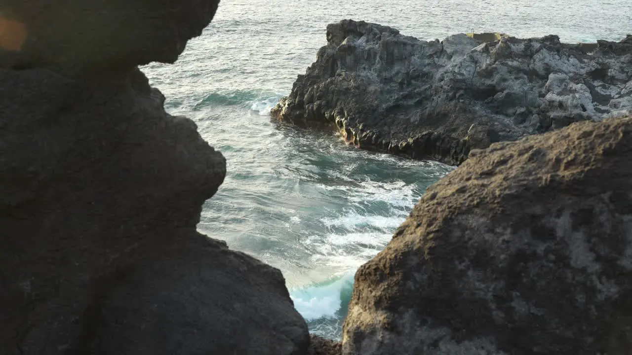 Ocean waves crash against rocky rugged beach in Los Gigantes Tenerife