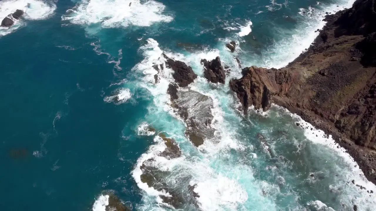 Waves crashing on a coast with rocks blue ocean aerial drone bird view