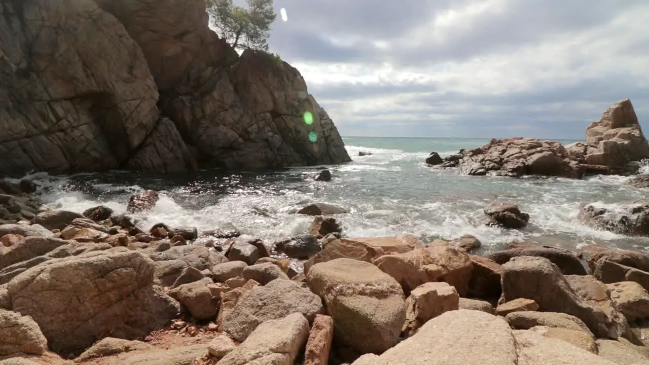 waves crashing on a rocky beach in lloret de mar spain in summer 50 fps slow motion