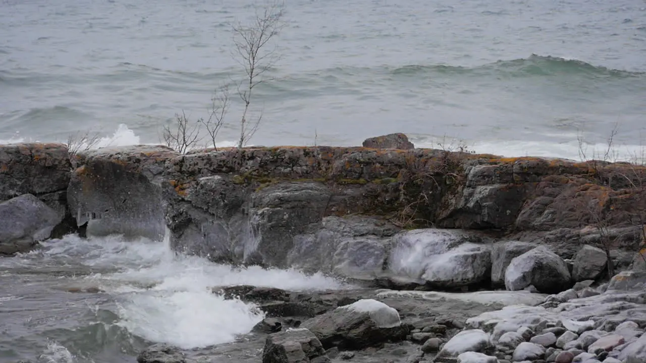 Slow motion waves hitting rocky shoreline