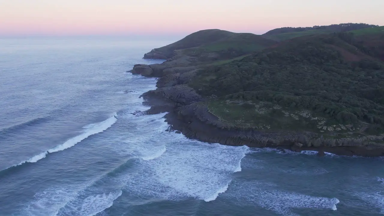 Spain's Cantabrian rugged coast as sun sets over Bay of Biscay AERIAL 4K