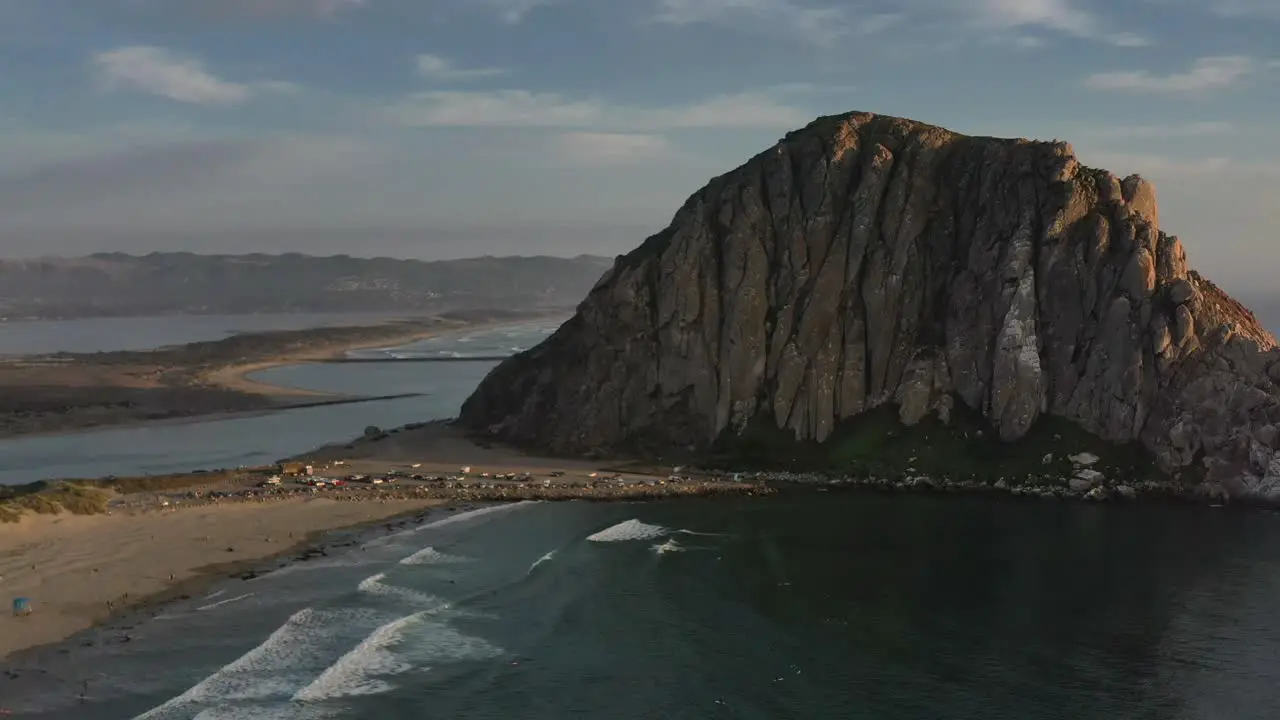 aerial view of Morro Bay Rock in California USA during sunset with sandy islands and mountains in the distance