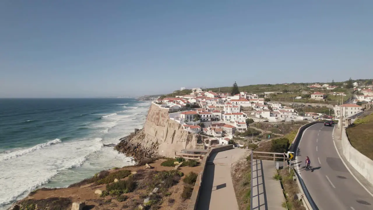 People walking on walkway along seaside cliff coastal road near Azenhas do Mar Portugal