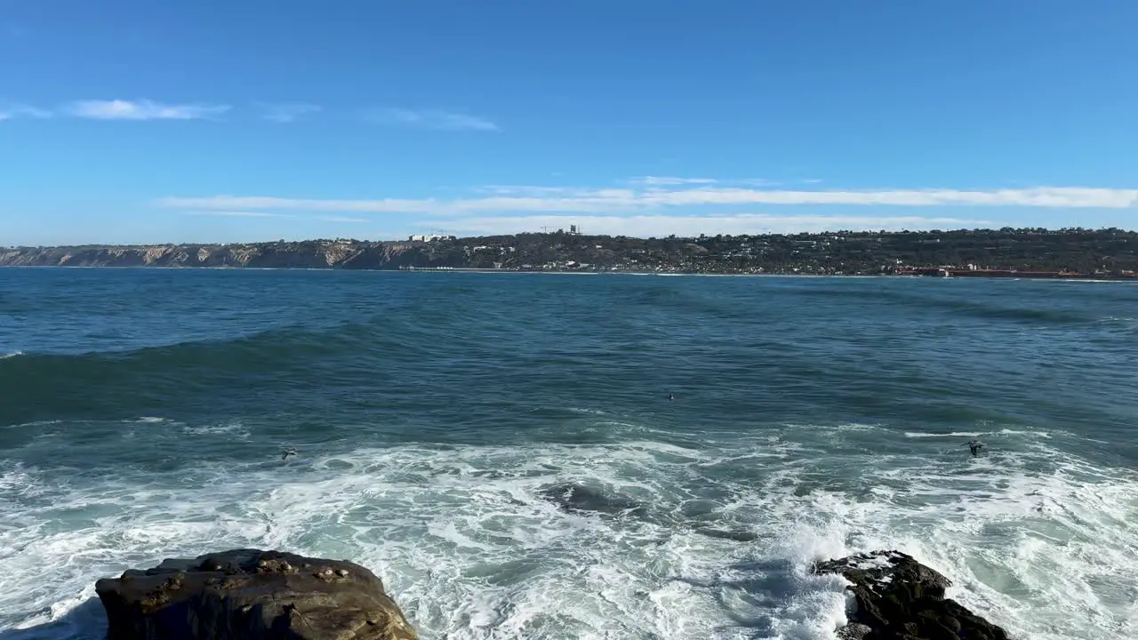 4K Footage of ruff water ocean swimmer with large waves at high tide in La Jolla Cove in San Diego California