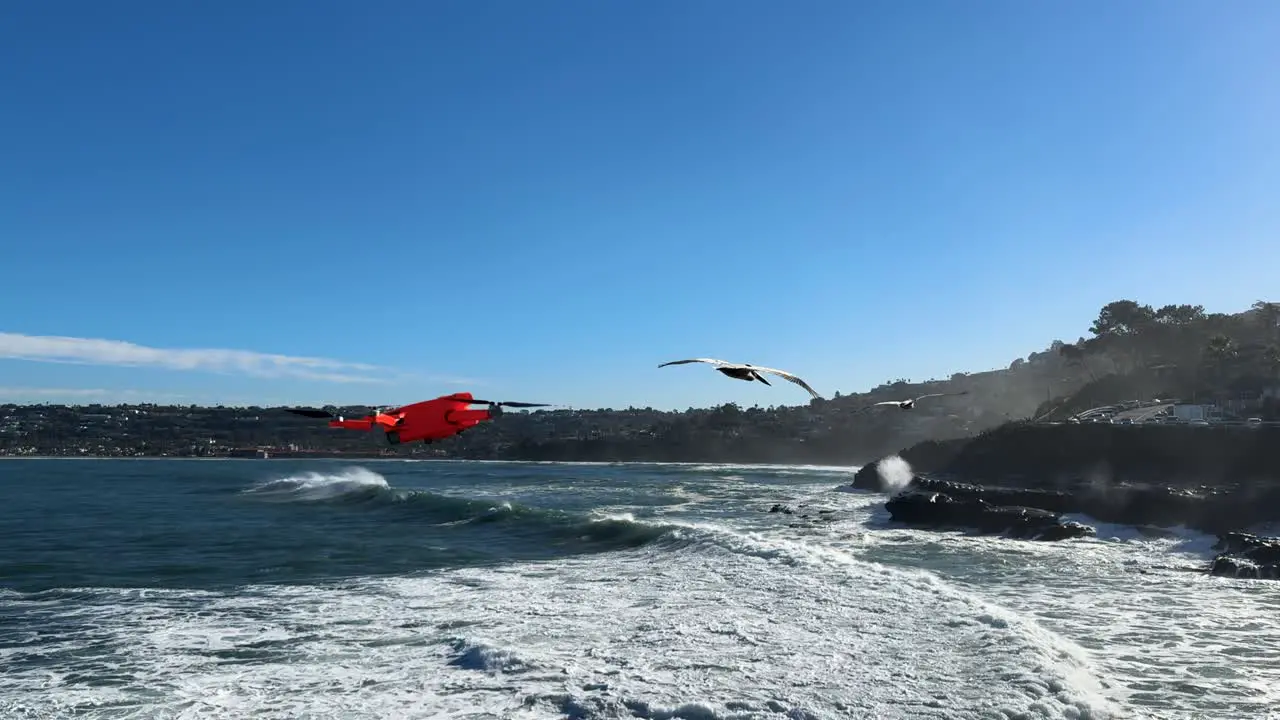 4K footage of drone flying left to right into and out of shot with large ocean waves crashing on cliffs during high tide in La Jolla Cove San Diego California