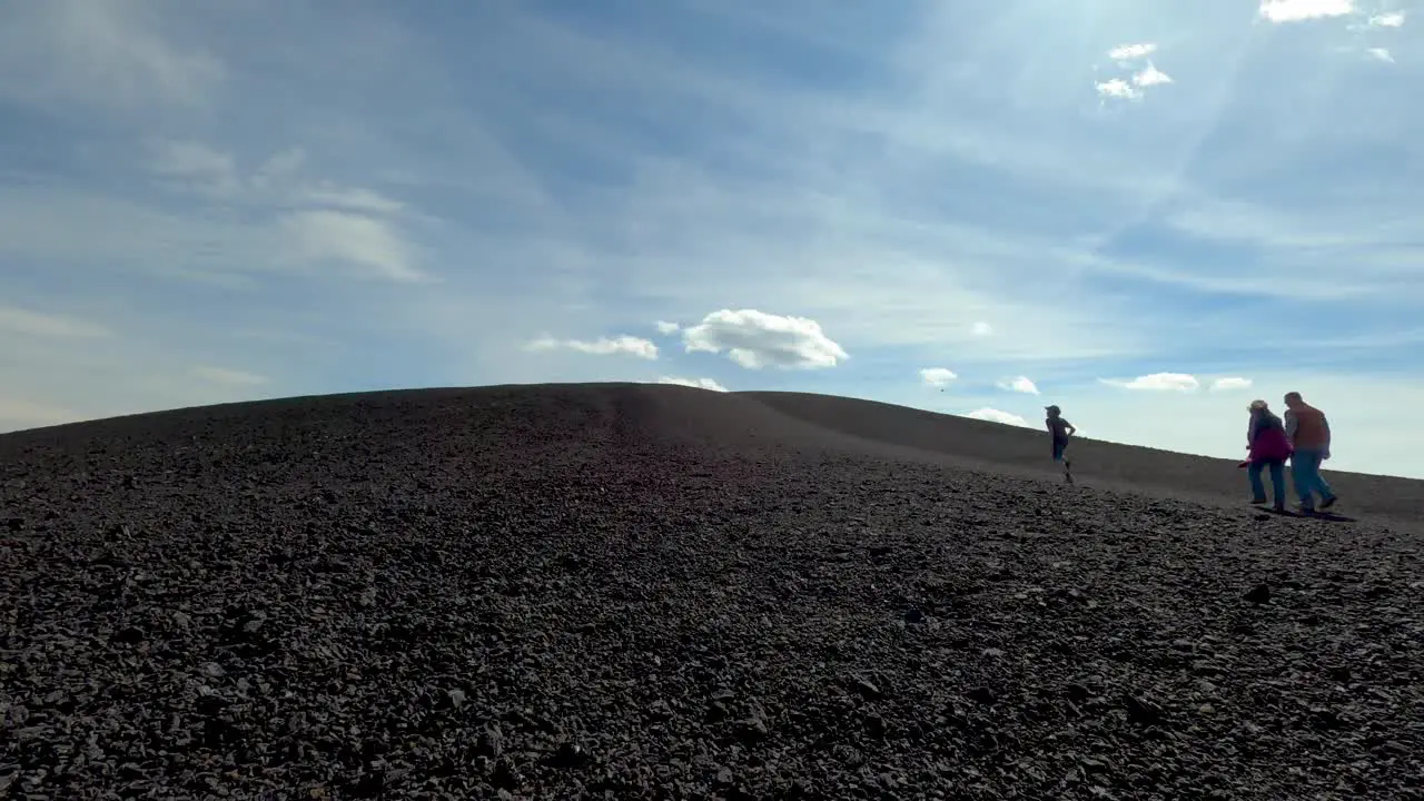 Timelapse of the giant cinder cone at the Craters of the Moon National Monument set against a windy blue sky and billowing clouds