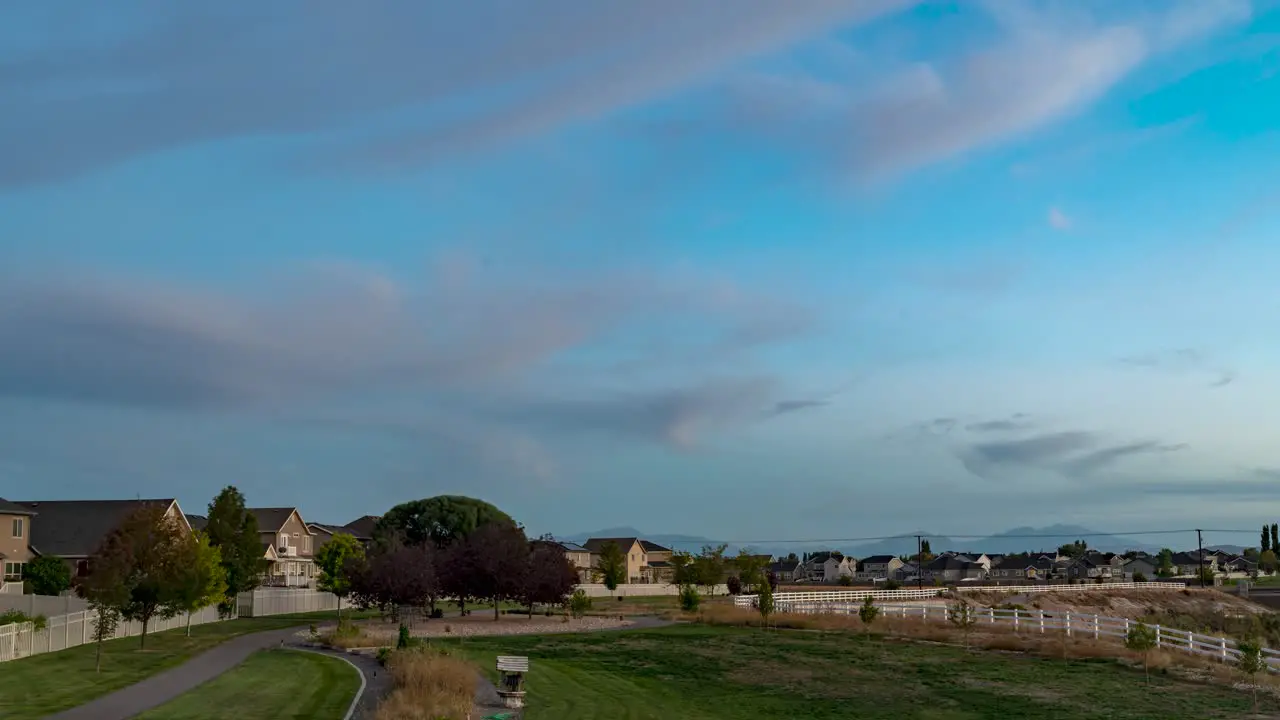 Sunset to darkness with the moon rising over a suburban neighborhood panoramic motion time lapse