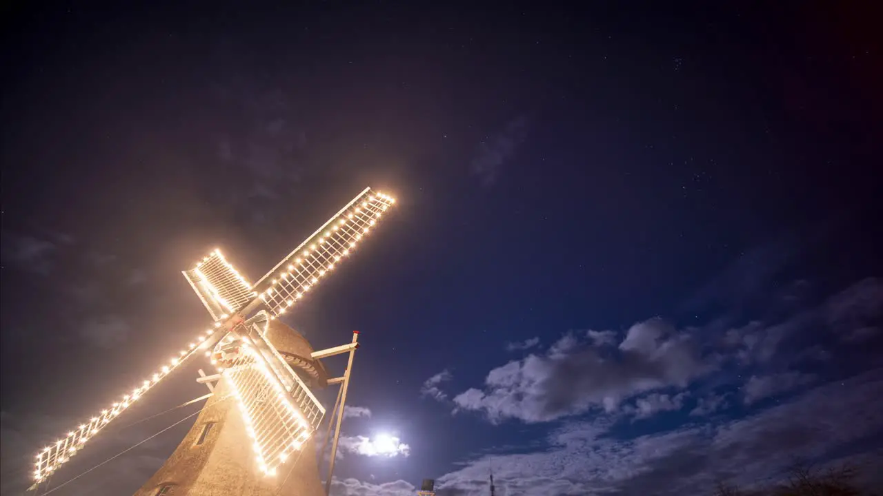 Windmill Illuminated In Lights Under A full moon Evening In Ameland Netherlands Low-Angle night Shot