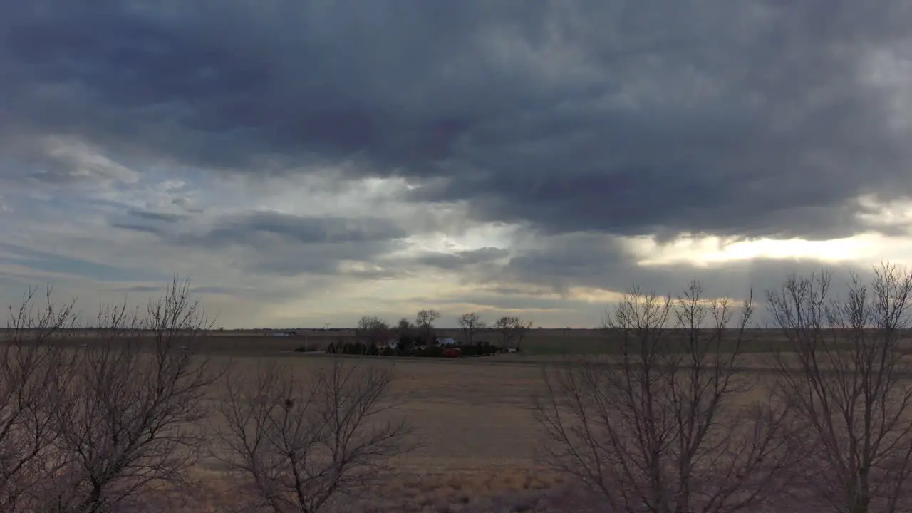 A backward dolly from a drone looking up at heavy skies near Sterling Colorado