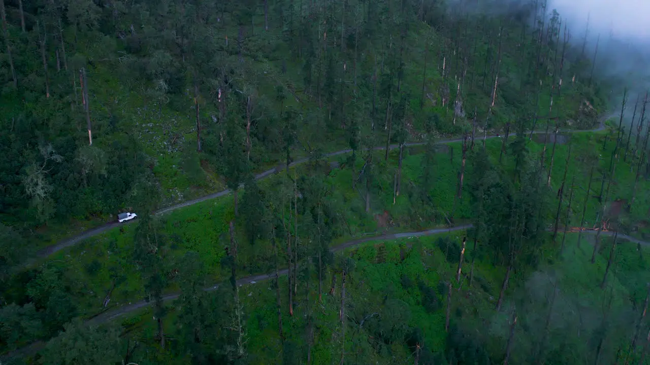 4x4 Jeep Travels off-road amid Nepal Forest landscape Fog covered Trees with clouds in monsoon season