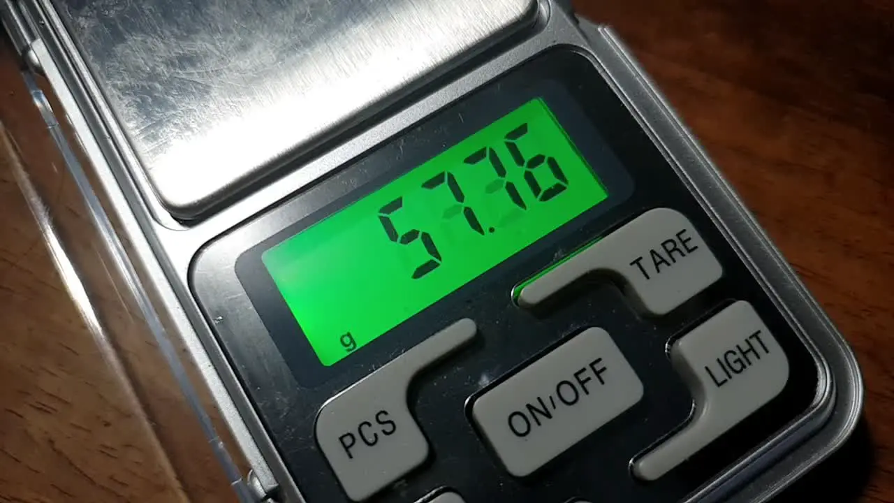 Pocket digital LCD precise scale in grams and ounces measuring and weighing ending in scary and ominous triple six number on the number digit display screen