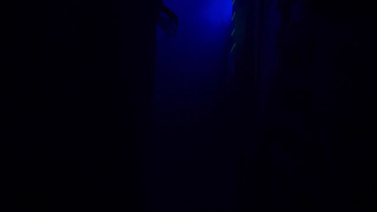 SLOW MOTION Inside a creepy haunted house during Halloween with black lights and strobes mannequins skulls clowns evil rabbits and spooky designs