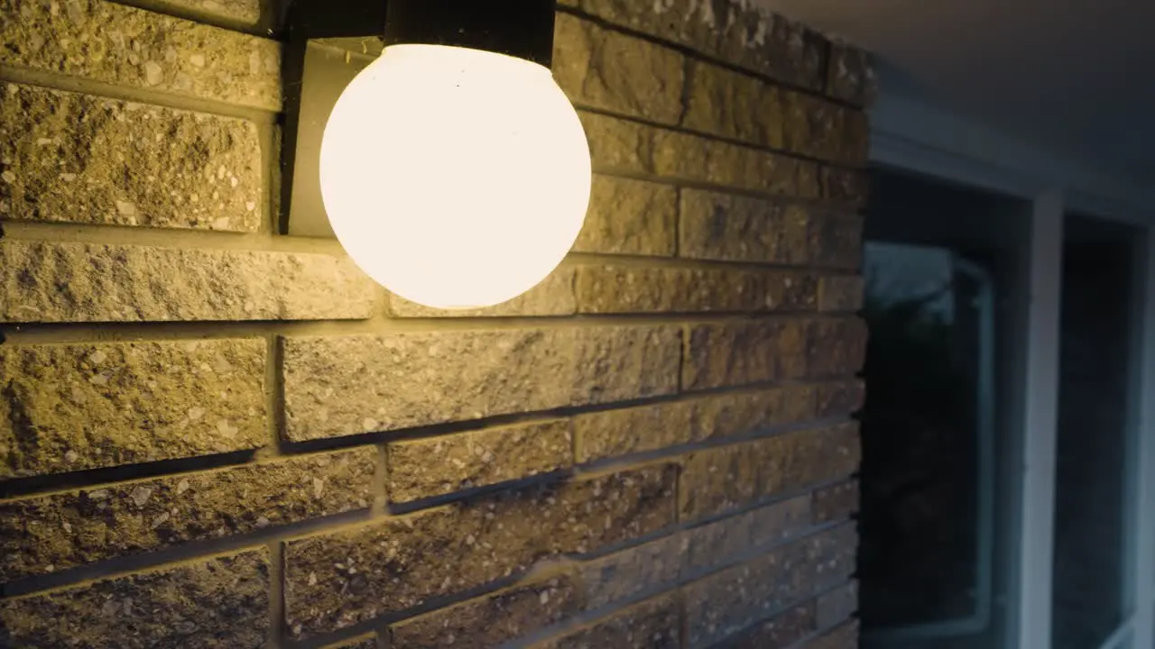 An exterior Home light illuminating a foggy Fall evening