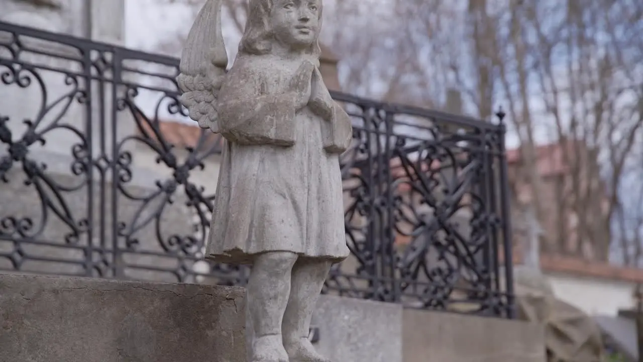 Statue of Little Angel on Pedestal in front of Gravestone in Bernardinai Graveyard