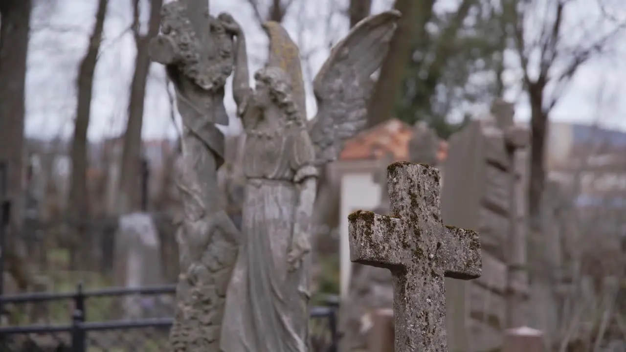 Rack Focus from Old Stone Cross to Angel Carved from Stone in a Graveyard in Uzupis