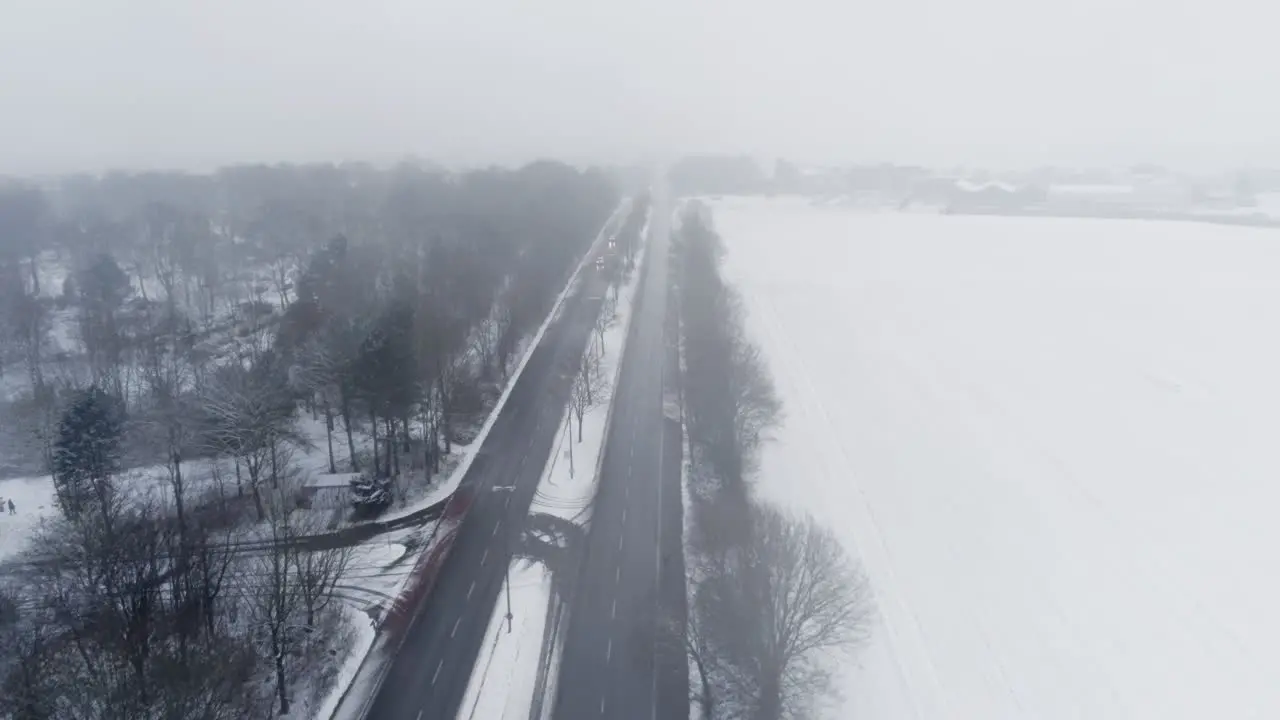 Aerial View Dense Fog and Light Highway Traffic in Snowy Countryside of Germany on Gloomy Winter Day Drone Shot