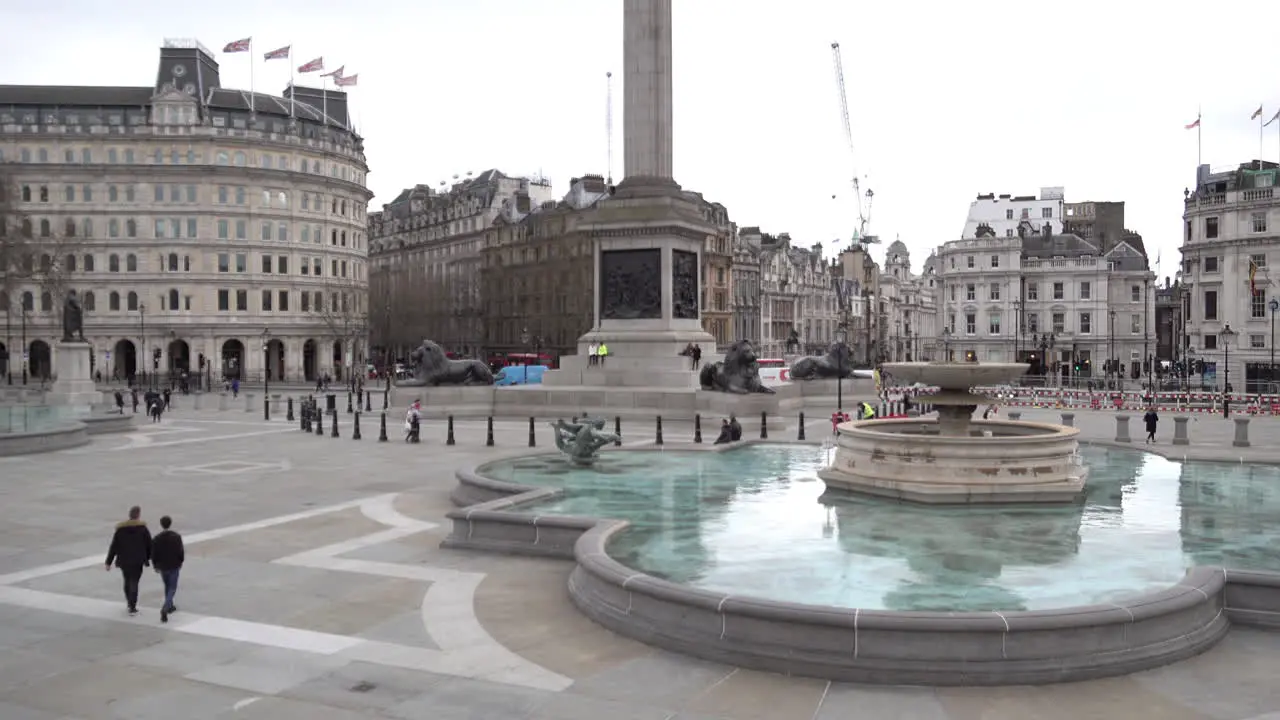 A few people walk across an empty Trafalgar Square he day after Prime Minister Boris Johnson warns the UK population to avoid all non-essential social contact due to the Coronavirus outbreak