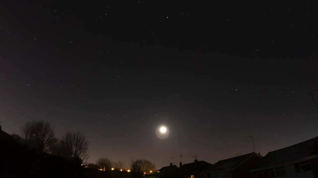 A winter moon passing through a starlight south east sky into a misty dawn in the UK