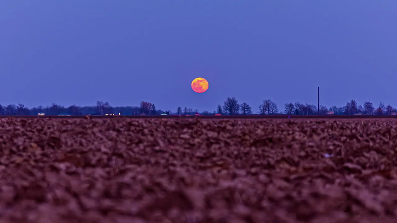 Low angle of infertile soil with full moon moving on top of a countryside