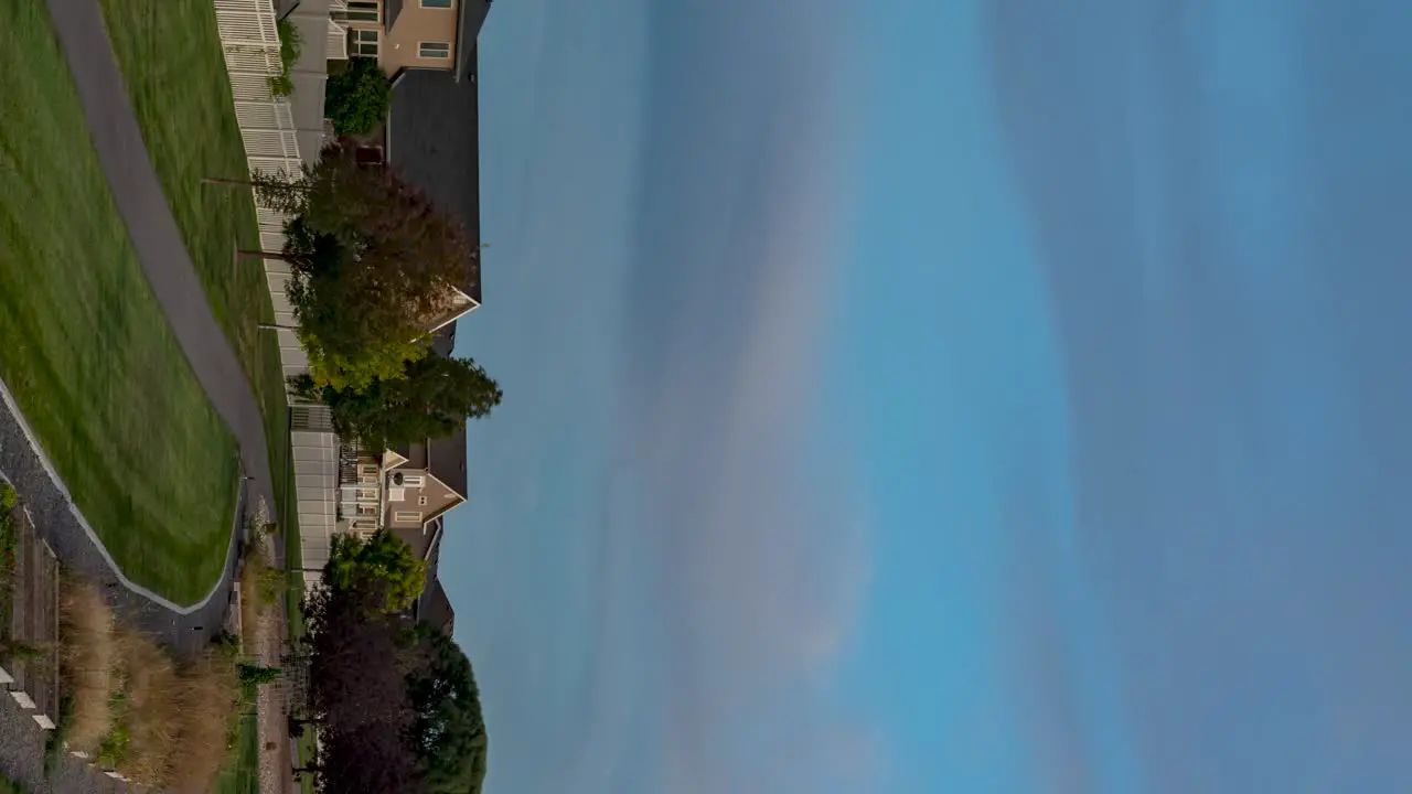 Panoramic time lapse of a park in a suburban community from sunset to the moon rising over the neighborhood vertical orientation