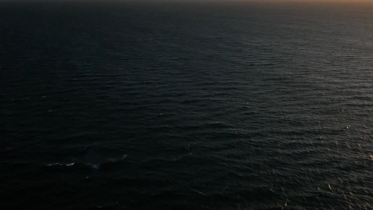 Drone above ocean revealing epic cloud covered Table mountain sunset silhouette