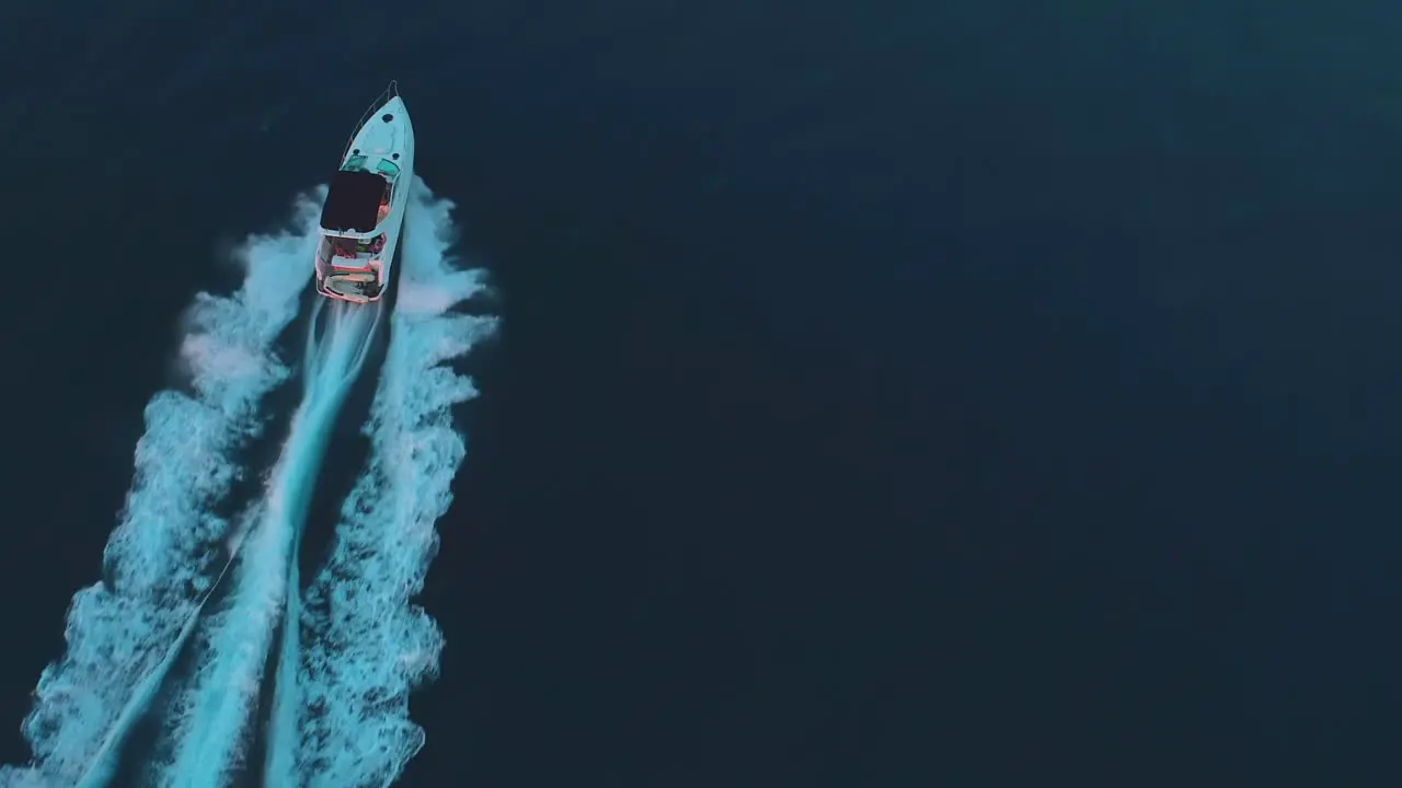 Aerial shot of a luxury speed boat riding on the ocean at sunset