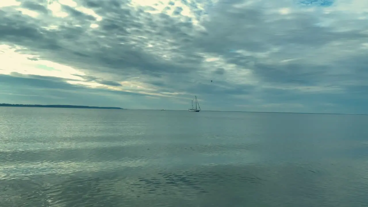 Lonely ship parking on wide ocean during cloudy and windy day static wide shot