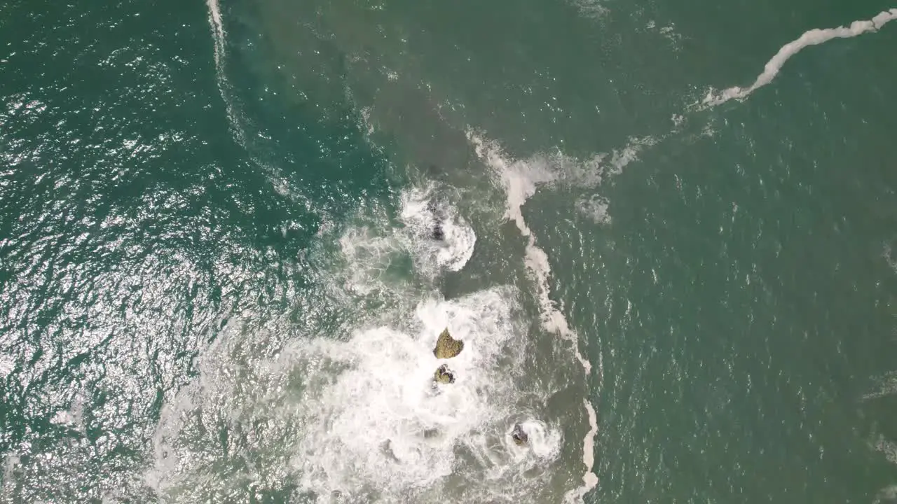 Vertical straight down view of beautiful sea water crashing on rocks at Nazare Portugal