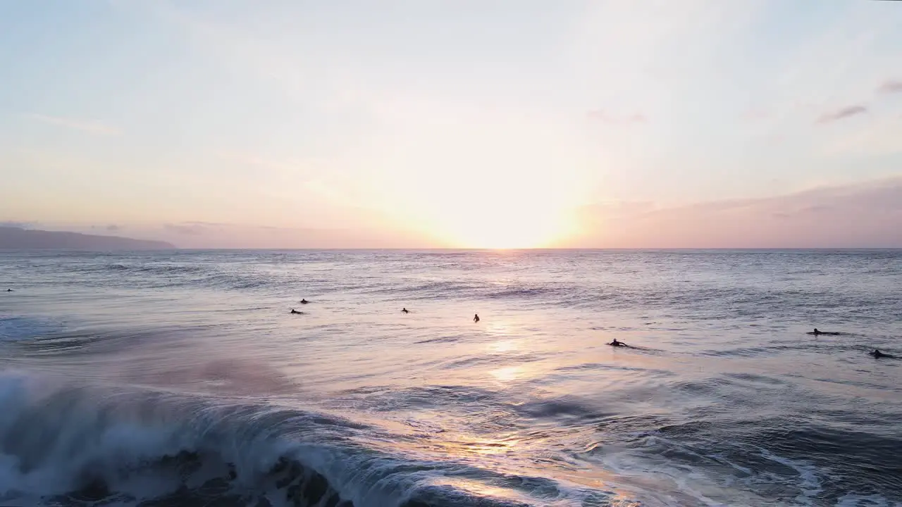 Surfers at sunset O'ahu North Shore Hawaii Pacific Ocean 4K aerial view