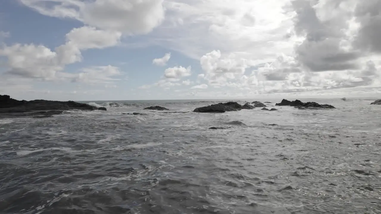 Aerial truck left of sea waves near rocky shore on a cloudy day in Dominicalito Beach Costa Rica