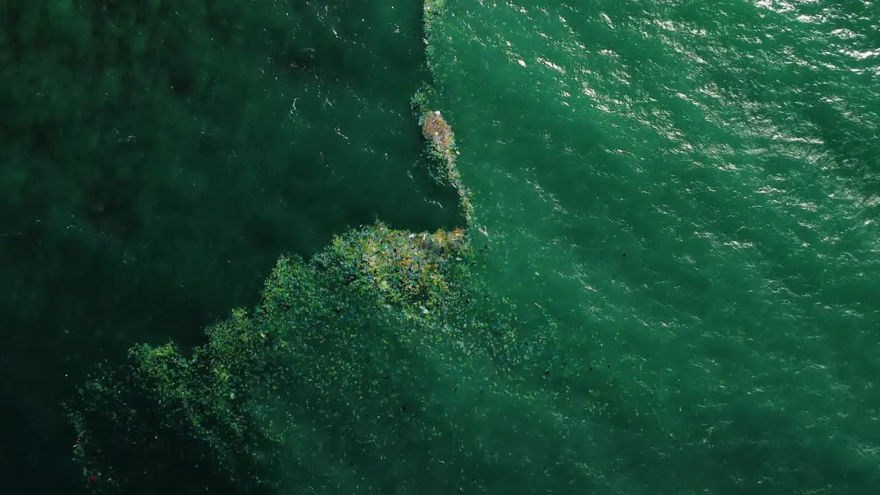 Aerial birdseye approaching disposable plastic bags floating in ocean