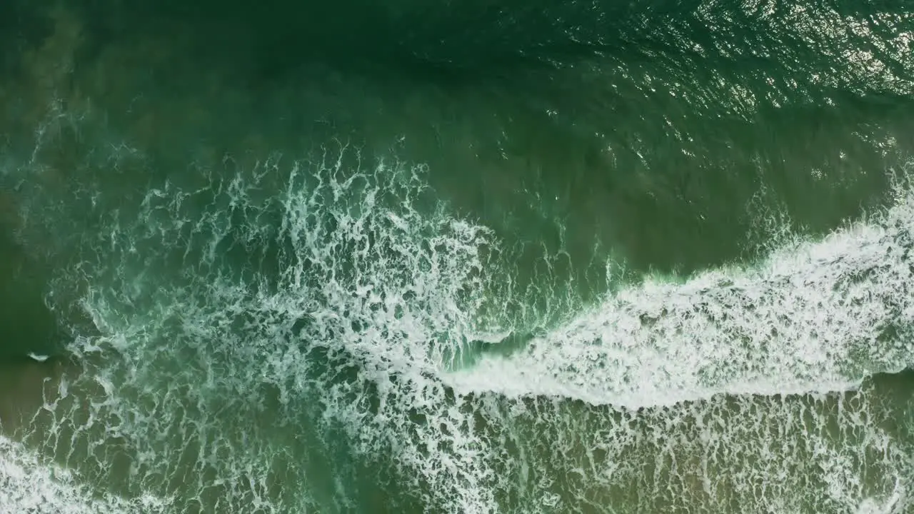 Aerial views of tropical waves rolling into the shore