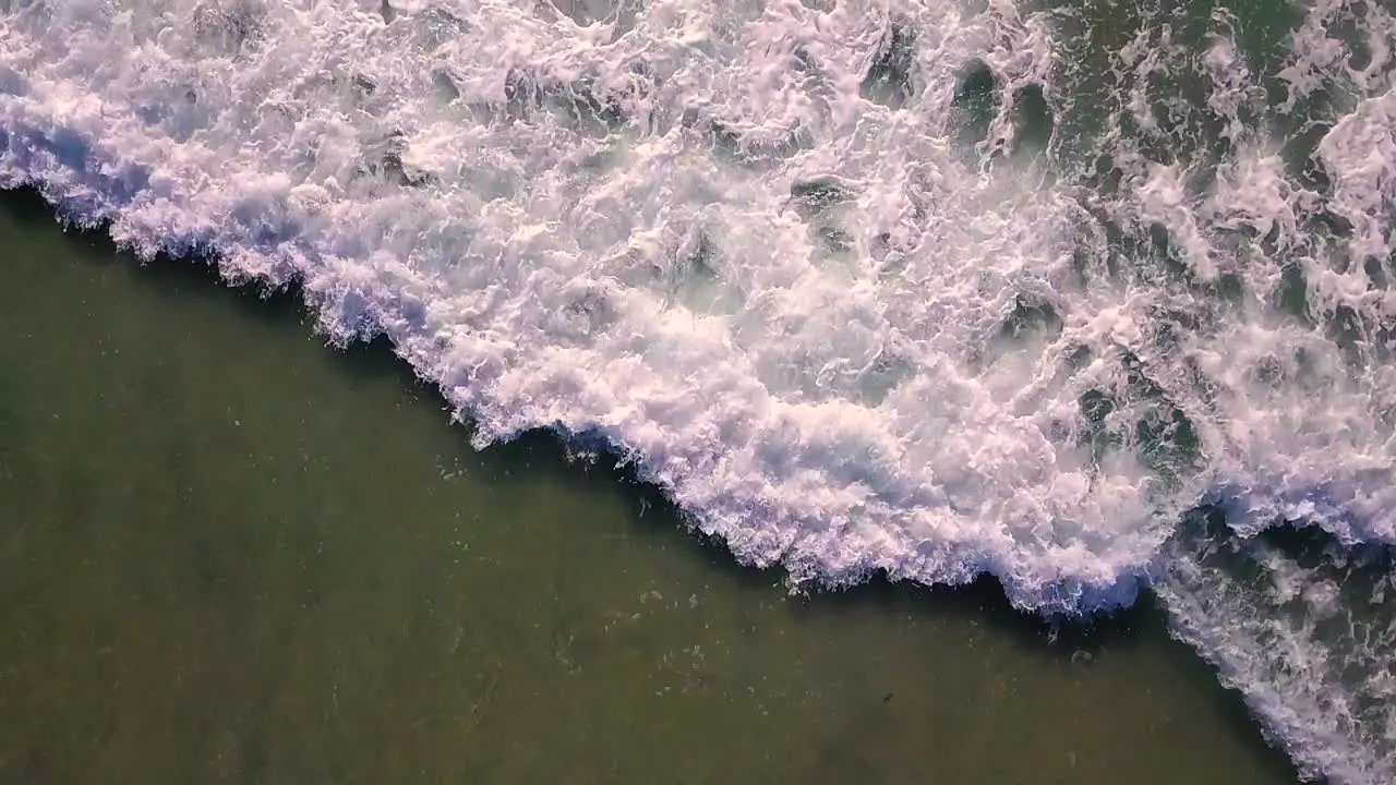 Aerial footage of waves rolling into shore off the coast of Southern California