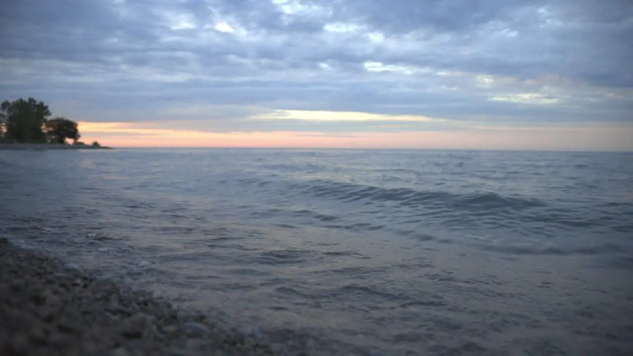 Beautiful Waves Splashing Gently Onto The Shore During Sunset Wide Shot