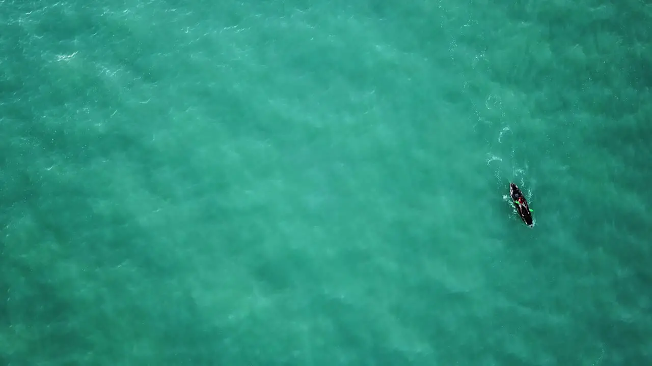 Aerial footage pointed down at deep blue water and kayaker