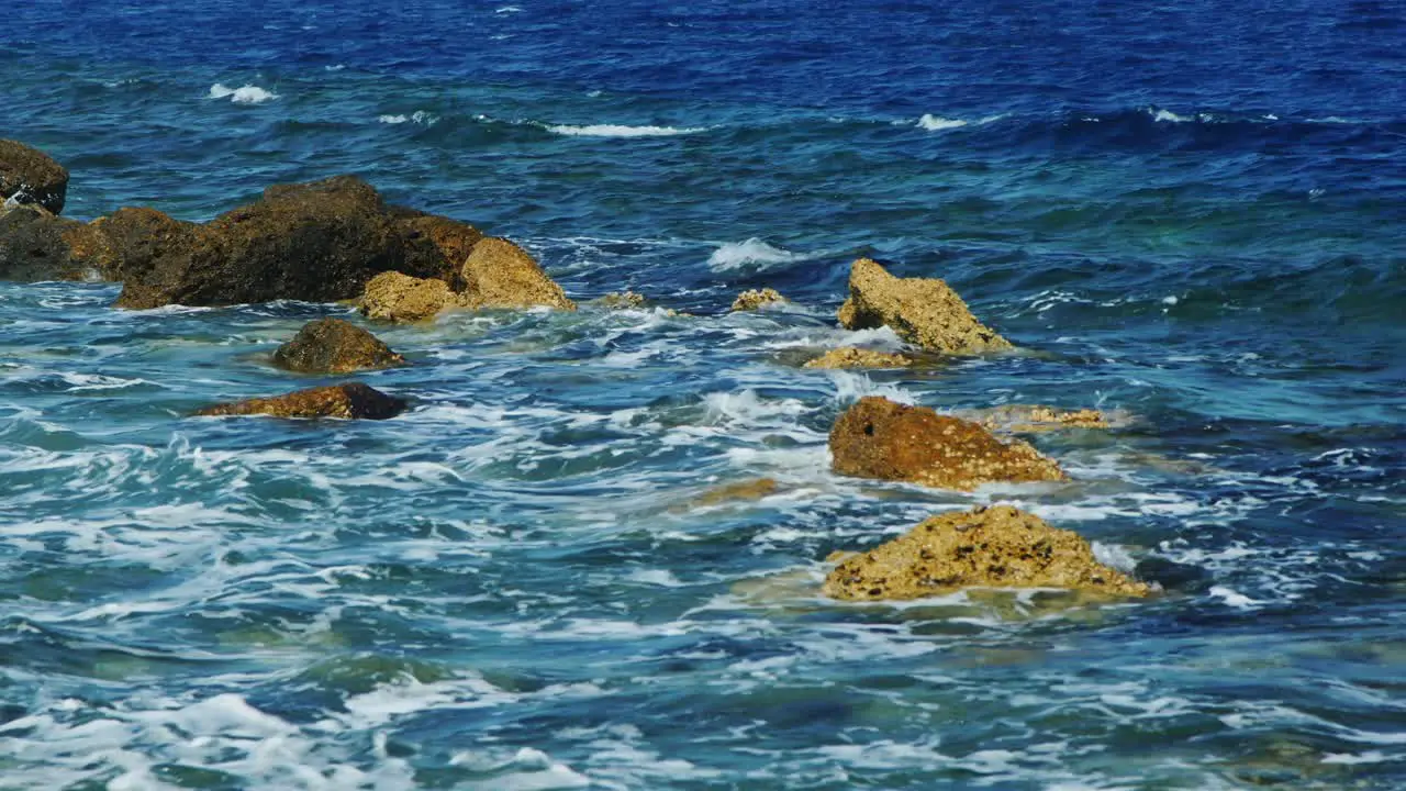 Waves Breaking On Rocks On A Sunny Day