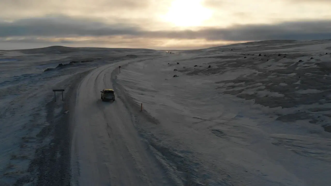 Aerial View Car on Icy Road in Highland of Iceland With Stunning Sky on Horizon  Cinematic Drone Shot