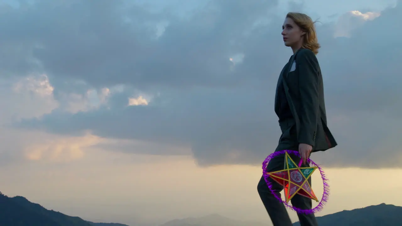 Slow motion shot of a woman walking holding a star lantern celebrating a festival