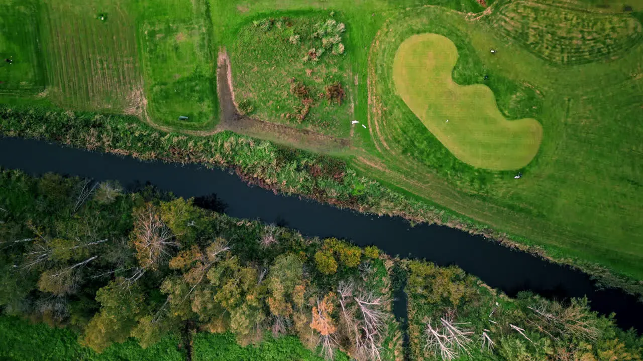 Moving top shot of a golf course in Espoo Finland passing a small river