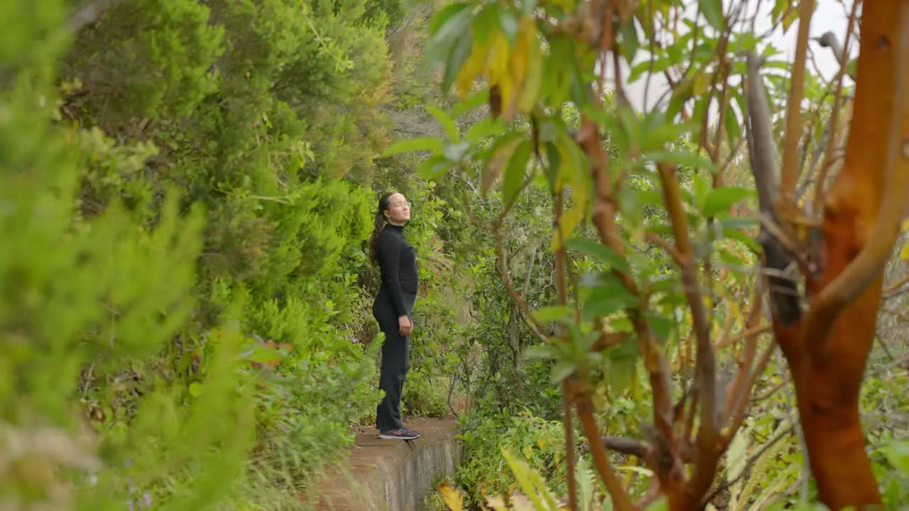 Lonely woman enjoys deep forest of Tenerife island distance view