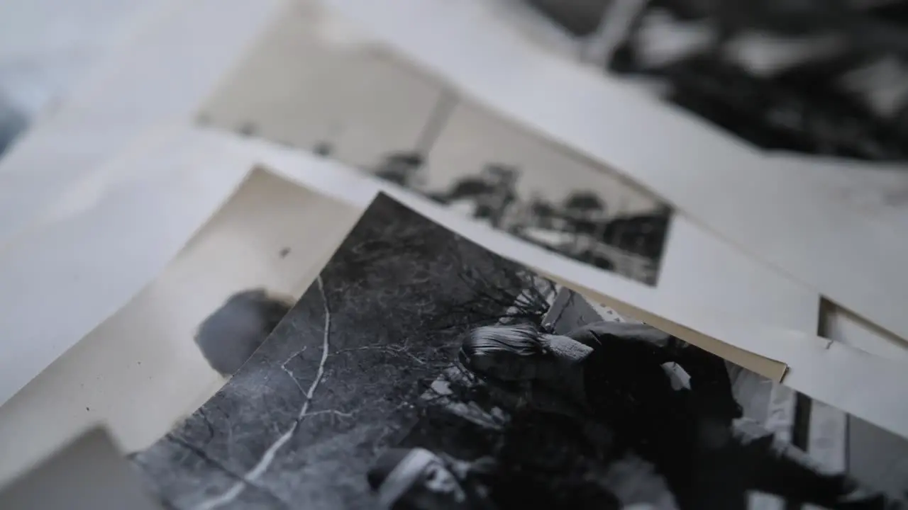 A close up shot of old black and white portrait photographs of people from the 80s laid out on a table together