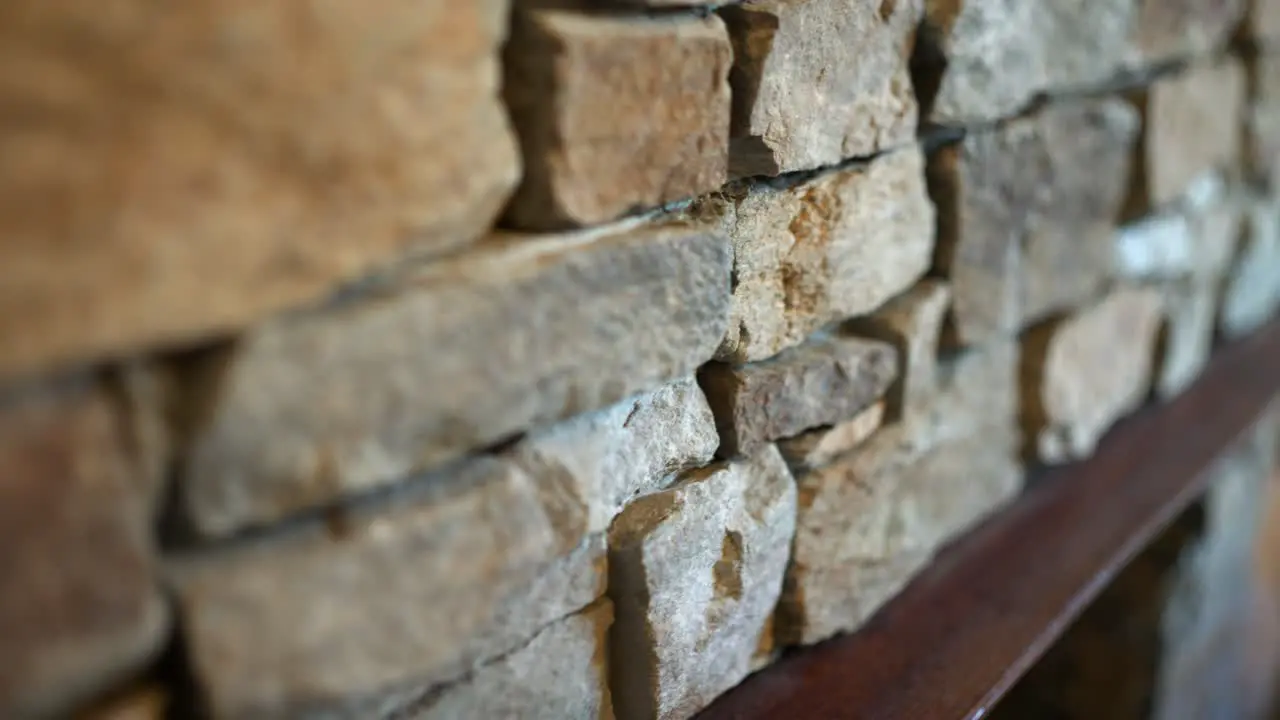 Rustic and rough interior stone work above fireplace with rocks of different shape size and colour for a rugged old fashioned look