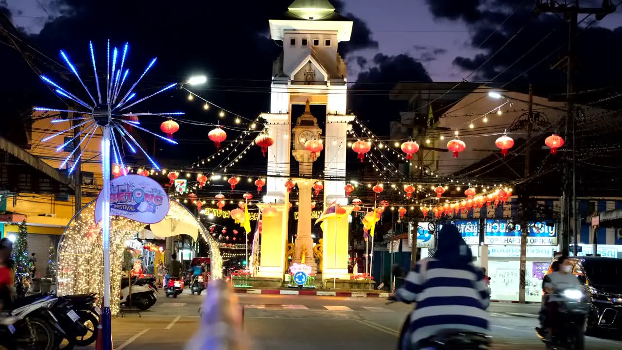 night scene of the Betong town clock tower with colorful Chinese lanterns and people during the festival