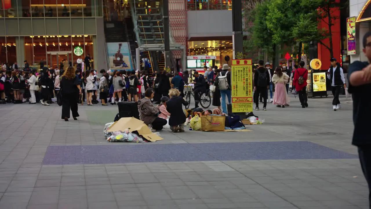 Slow motion pan of urban center of Shinjuku crowds gathering