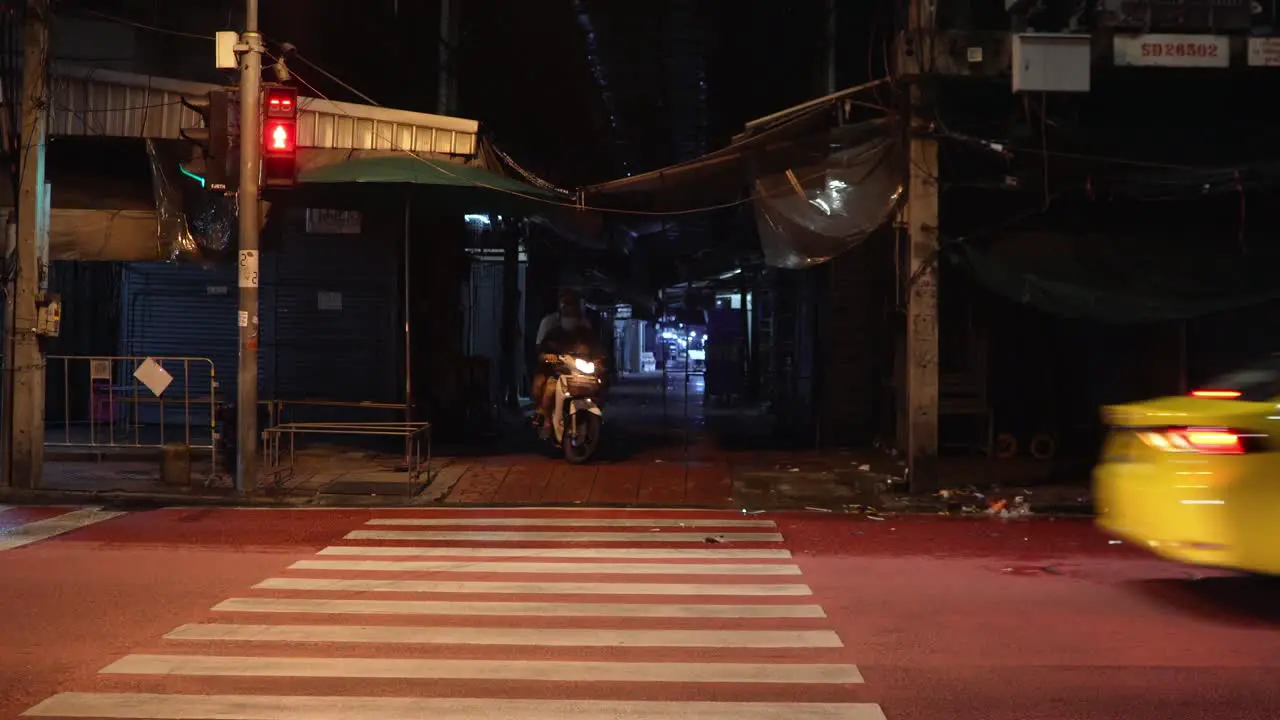 Scooter coming out of a small alley trying to get in to the traffic in Bangkok Thailand during the pandemic