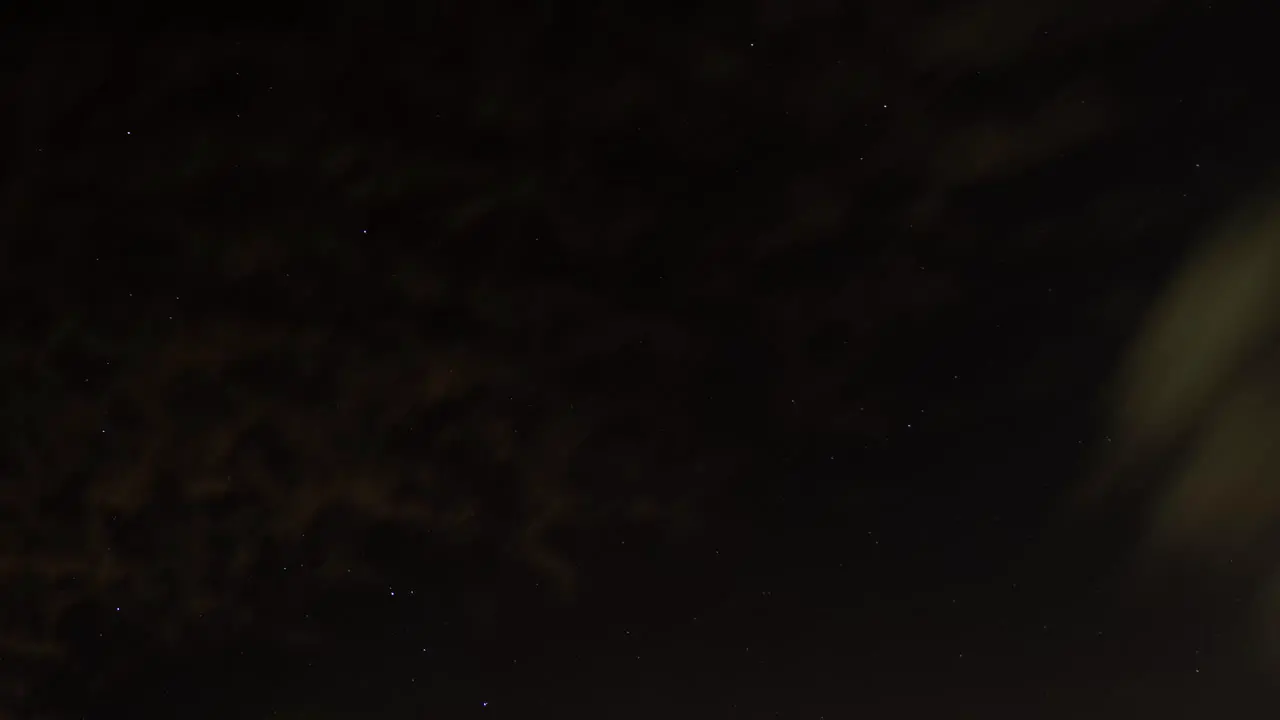 Clouds passing by in front of stars time lapse background