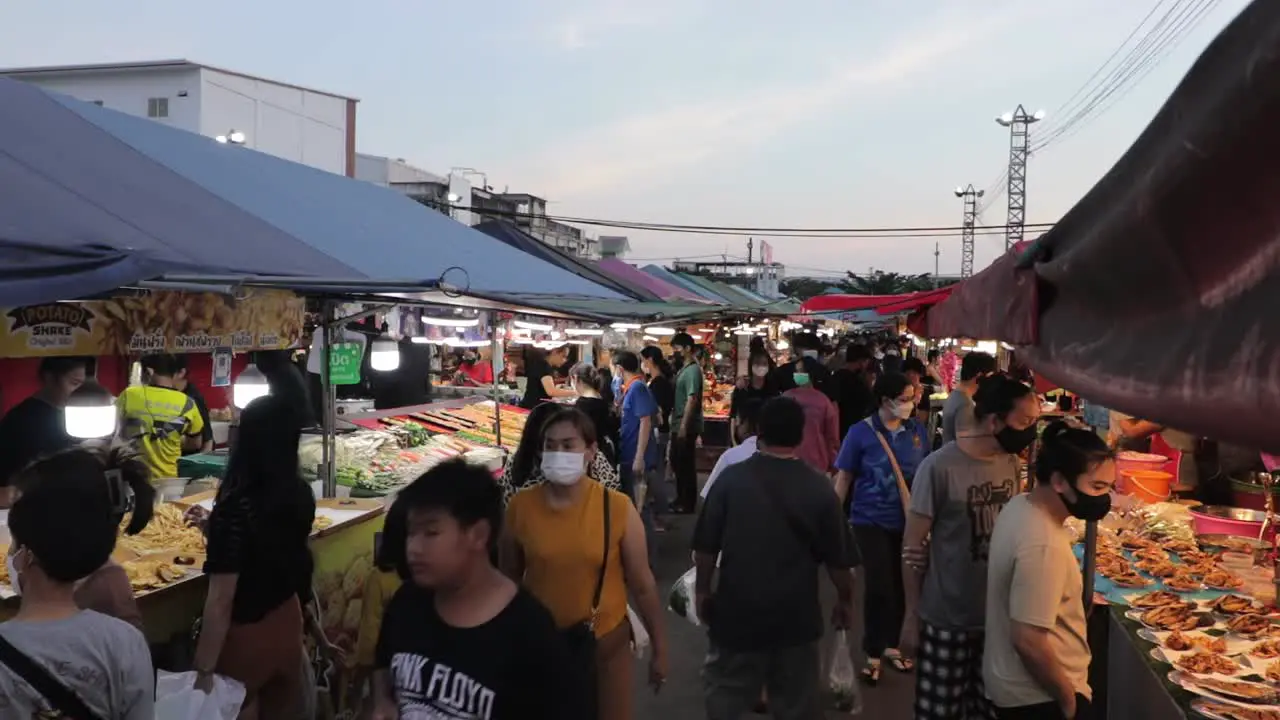 Crowd Of People Walking Through Food Stalls At Night Market At Dusk In Rayong Thailand